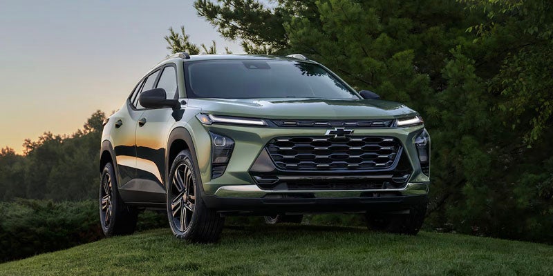2024 green Chevy Trax on grassy landscape at sunset